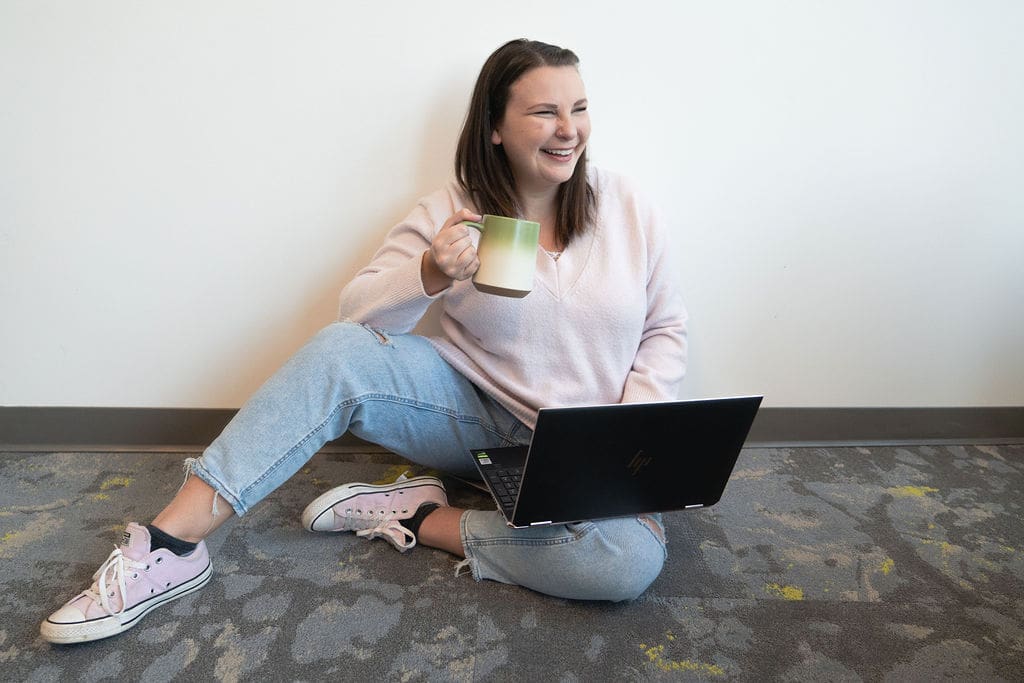 Photographer Business Coach laughing while holding a mug helping photographers grow